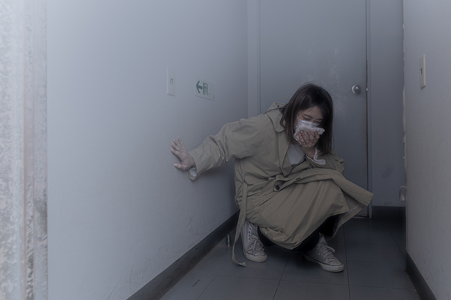 煙が蔓延した迷路の部屋から出口を探す「煙避難体験コーナー」の写真